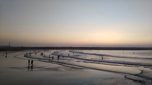 Scenic view of snowy landscape against clear sky during sunset