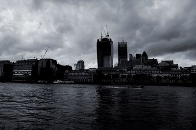 River in city against cloudy sky