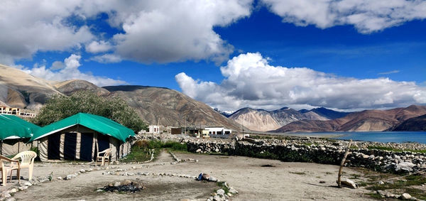 Scenic view of road by mountains against sky