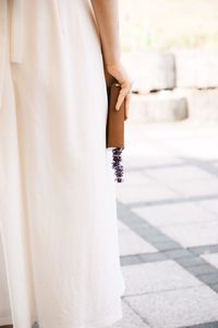 Midsection of woman standing by white flower