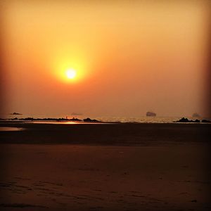 Scenic view of beach against orange sky