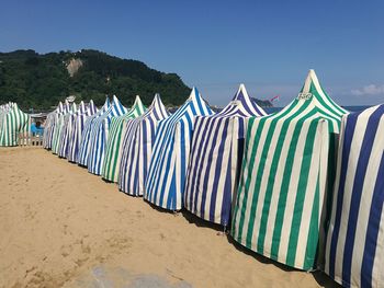 Multi colored umbrellas on beach against clear blue sky