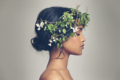 Beautiful young woman standing against wall