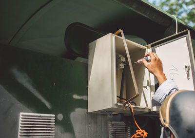 Close-up of technician repairing electric meter