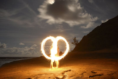 Light painting at beach against sky at night