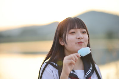 Portrait of smiling young woman drinking coffee