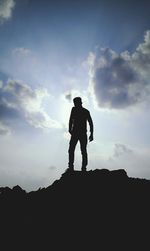 Silhouette man standing on mountain against sky