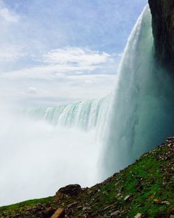 Low angle view of waterfall against sky