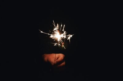 Close-up of hand holding sparklers at night