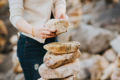 Midsection of woman holding rock