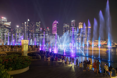 People at marina bay sands view spectra show of dancing fountains, light and water show 