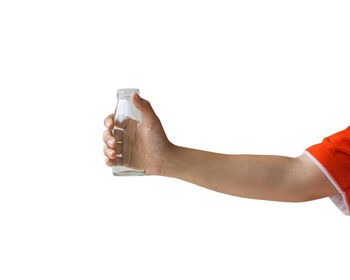 Close-up of hand holding bottle against white background