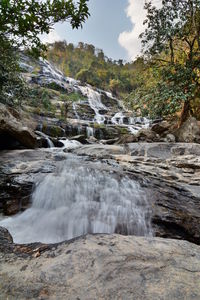 Scenic view of waterfall against sky