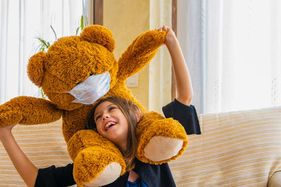 Smiling girl playing with teddy bear