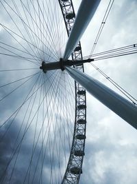 Low angle view of millennium wheel against cloudy sky