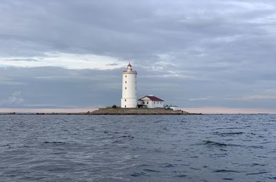 Lighthouse by sea against sky