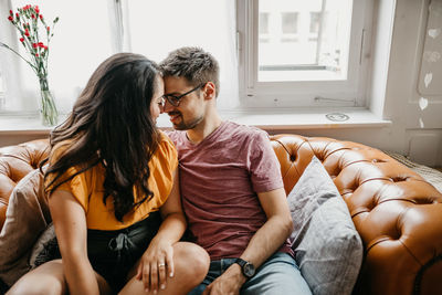 Young couple sitting on sofa at home