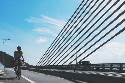 Low angle view of woman walking on bridge