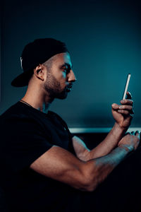 Side view of young man looking on iphone 