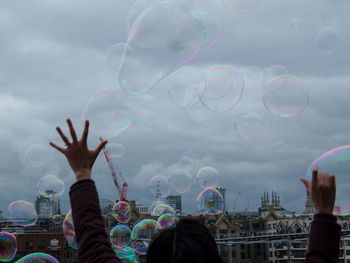 People in mid-air against rainbow in sky