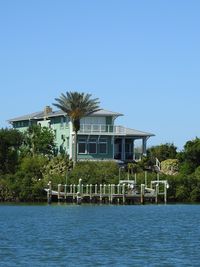 Building by palm trees against clear blue sky