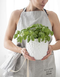 Midsection of woman holding plant