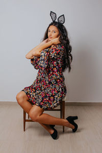 Portrait of young woman against wall