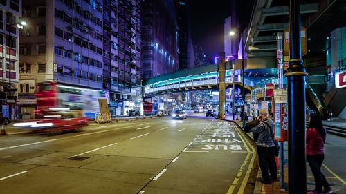 People waiting at bus stop on street