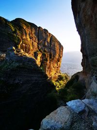 Rock formations by sea against sky