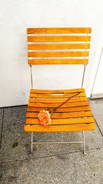 High angle view of orange empty bench on table against wall