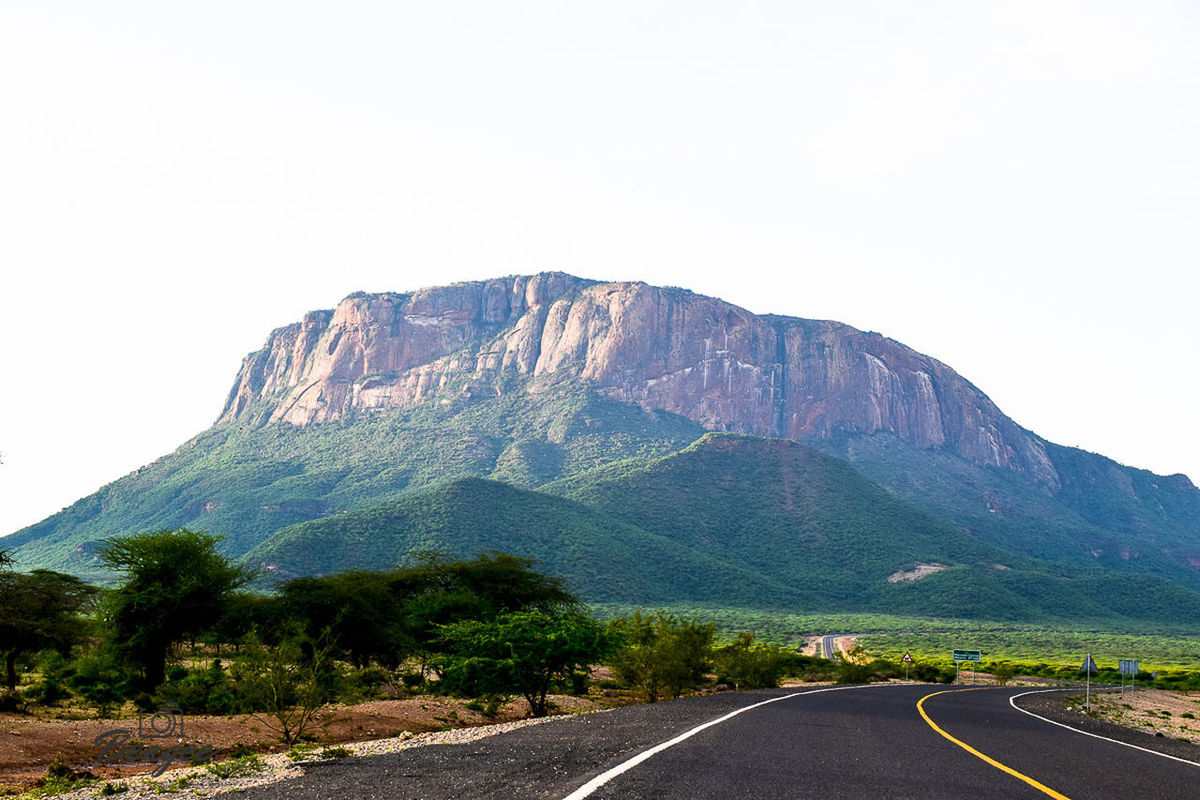 ROAD AMIDST MOUNTAINS AGAINST CLEAR SKY