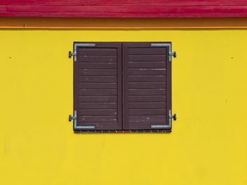 Closed door of yellow wall