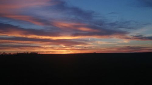 Silhouette landscape against sky at sunset