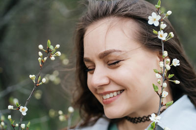 Portrait of a beautiful smiling joyful girl in cherry blossoms in spring