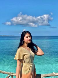 Young woman looking at sea against sky