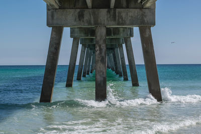 Wooden pier on sea against sky