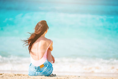 Rear view of woman enjoying at beach