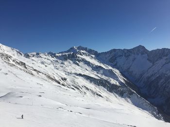 Scenic view of snowcapped mountains against clear blue sky