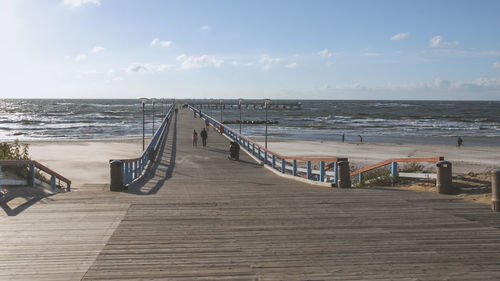 Boardwalk on beach against sky