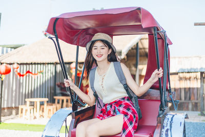 Portrait of smiling young woman sitting outdoors