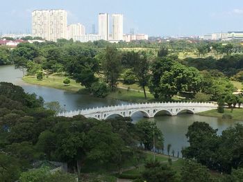 Bridge over river in city against sky