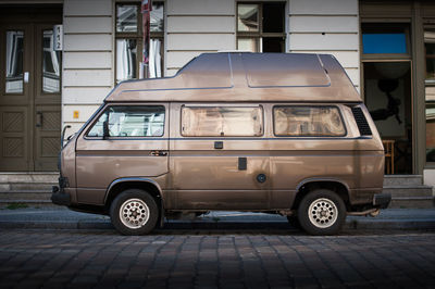 Vintage car parked on street against building