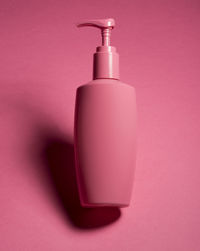 Close-up of bottle against pink background
