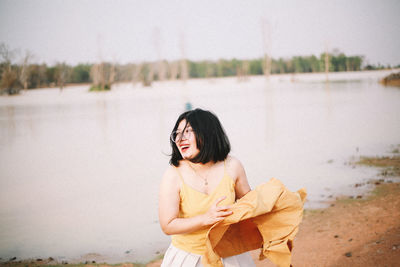 Young woman looking at lake shore