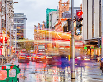 Blurred motion of vehicles on road by buildings in city