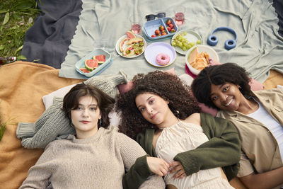 Portrait of teenage girls relaxing at picnic