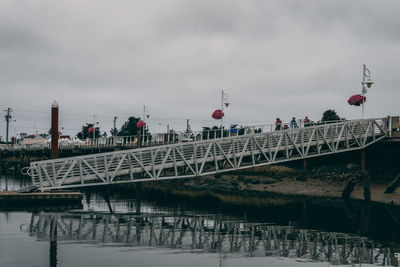 Bridge over river against sky in city