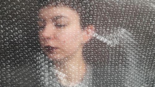 Close-up of young woman with bubble wrap