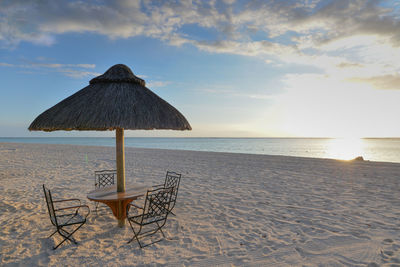 Lifeguard chair on beach against sky