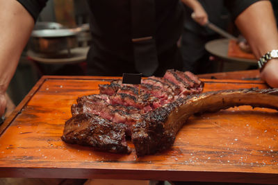 Midsection of man preparing food on barbecue grill